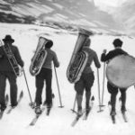 circa 1945:  Full-length image of four musicians wearing cross-country skis while toting their instruments on their backs through a snowy mountain range. They carry (L-R) a trombone, a tuba, a baritone tuba (euphonium), and a large drum.  (Photo by Hirz/Getty Images)